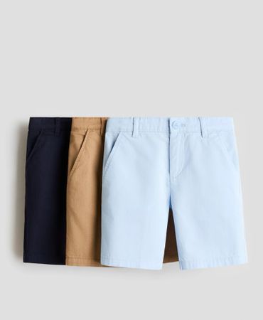 Three pairs of shorts in navy blue, tan, and light blue, neatly arranged.