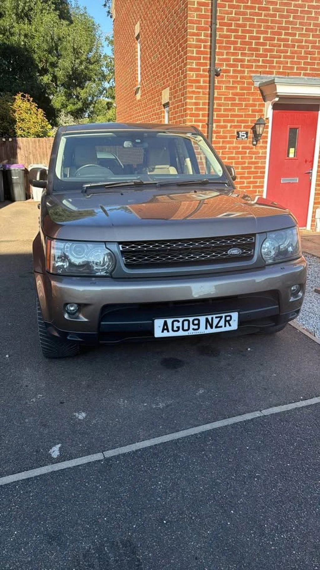 Front view of a gray Land Rover parked in driveway with license plate AG09 NZR.