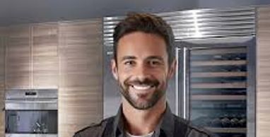 Smiling chef in modern kitchen with arms crossed.