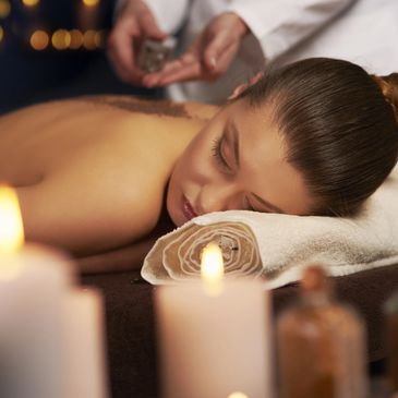 Lady relaxing having a massage with candles around her