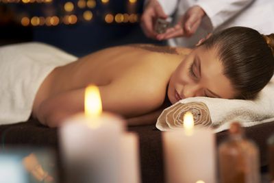 Lady relaxing with Swedish massage with candles around.