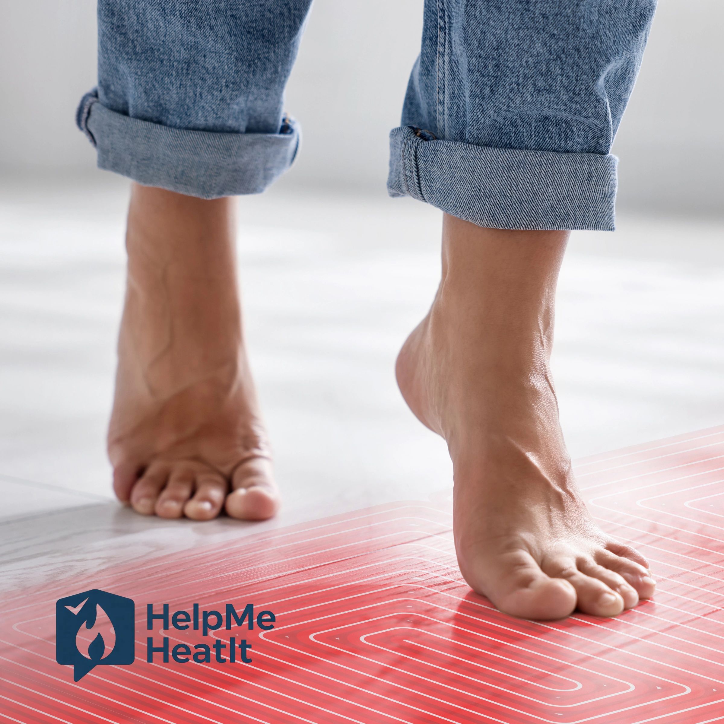 Close-up of barefoot person standing on a heated floor with jeans rolled up.