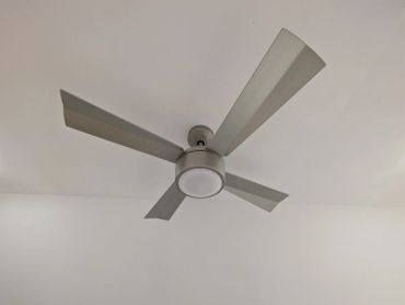 Modern ceiling fan with light mounted on a white ceiling.