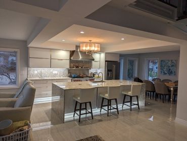 Modern kitchen with marble island and elegant lighting.