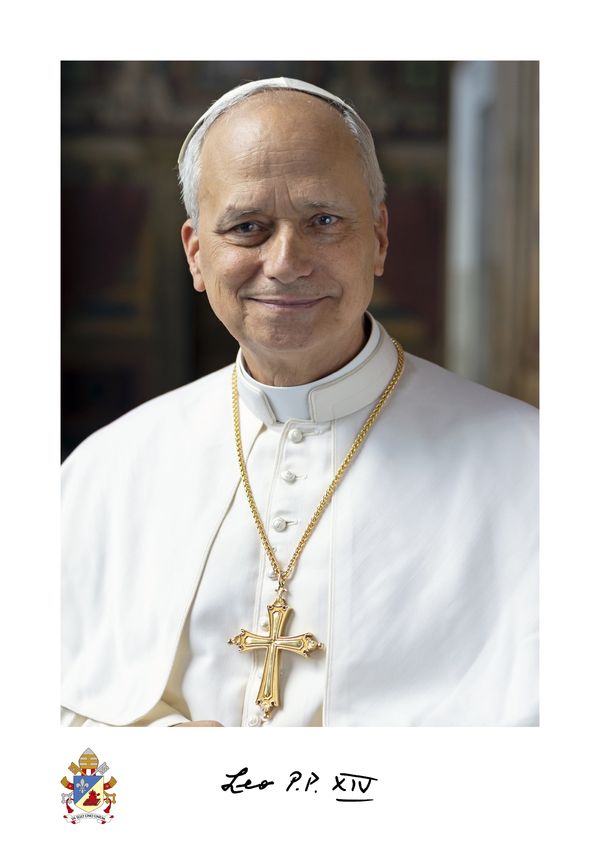 Portrait of a smiling elderly pope in white attire with a gold cross necklace.