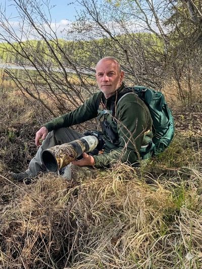 Man sitting with large lens.