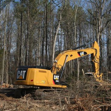 Excavator clearing land