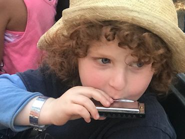 Child playing harmonica.