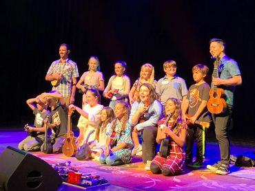 Elementary ukulele students on stage with Jake Shimabukuro.