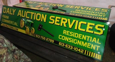 Green signboard for Daly Auction Services with contact numbers and services.