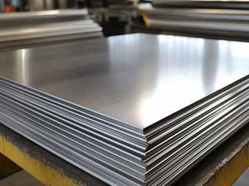 Stack of shiny metal sheets in a workshop.