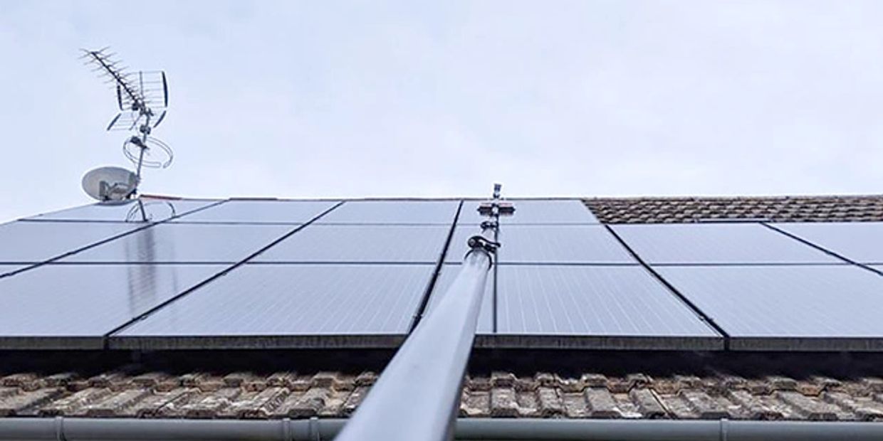Solar panel cleaning with a soft brush from the ground.