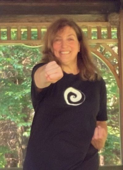 Certified Instructor in Dragon's Way Qigong® demonstrating  one of the Wu Ming Meridian stretches.