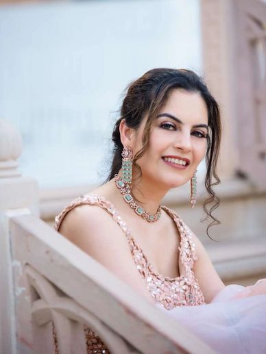 Smiling woman in elegant dress and jewelry.