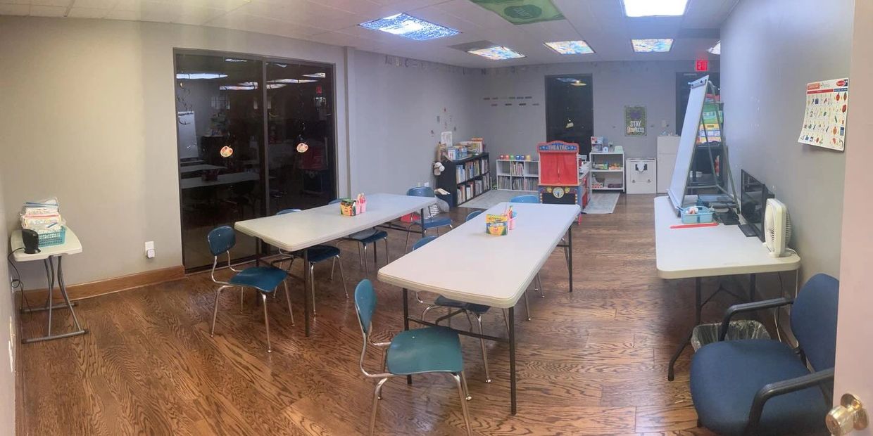 Classroom with tables, chairs, and educational materials.