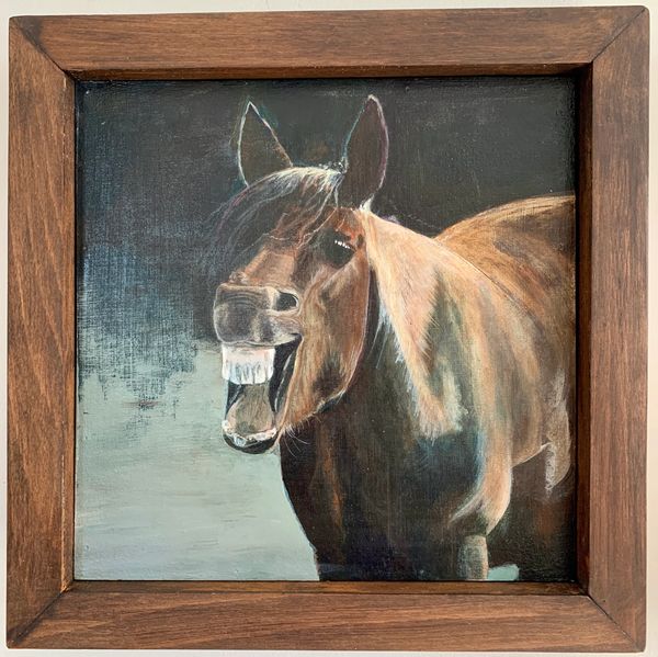 Peinture d'un cheval riant encadrée en bois.
