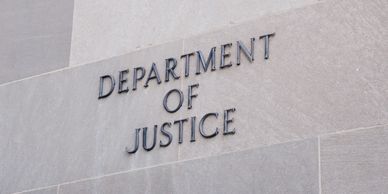 Sign on a stone wall reading 'Department of Justice'.
