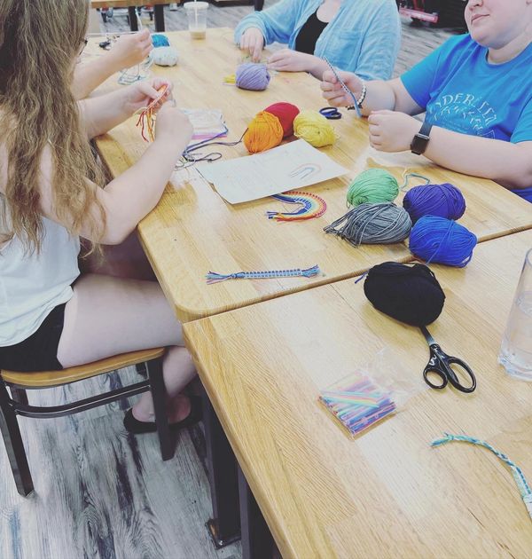 Group of teens working on plastic canvas weaving