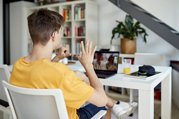 Young man video chatting while using sign language.