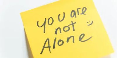 Sticky note says "You are not alone :)".