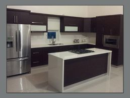 Cocina a la medida “custom” color wengue con cuarzo y cascadas