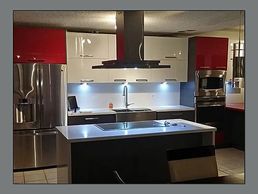 Cocina roja, gris y blanca en PVC a la medida con cascadas cuarzo. Construida en Puerto Rico.