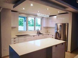 Cocina blanca en PVC a la medida con cascadas cuarzo. Construida en Puerto Rico.