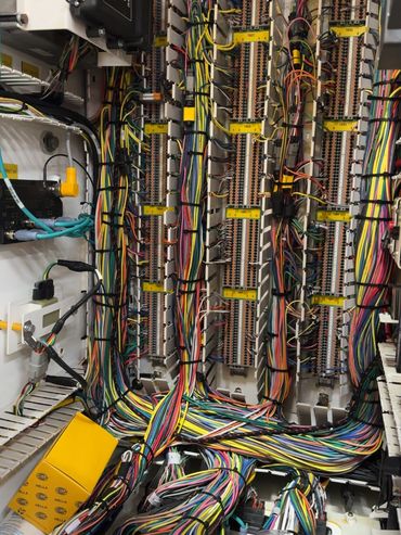 Organized colorful wiring and terminal blocks inside an electrical control panel.