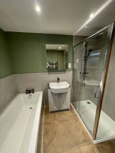 Modern bathroom with bathtub, sink, and glass shower enclosure.
