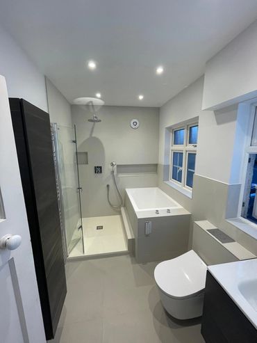 Modern bathroom with a walk-in shower, rectangular bathtub, and sleek toilet.