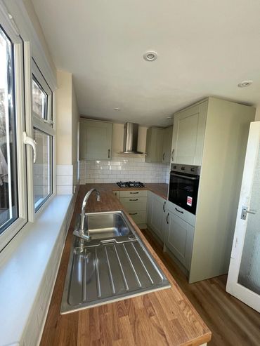 Modern kitchen with wooden countertops and stainless steel sink.