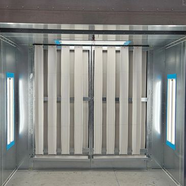 Metal chamber with vertical white strips and fluorescent lights.