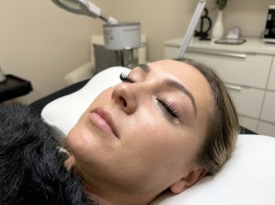 Woman with closed eyes in a beauty treatment room.