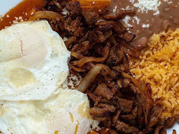Plate with eggs, grilled meat, rice, and beans.