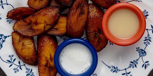 Plate of fried plantains with two dipping sauces, milk and caramel.