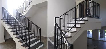 Black stair railings with vertical pickets and tall rectangular accents beside wood treads.