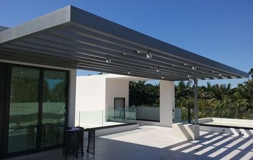 Gray aluminum beams shading an open rooftop terrace.
