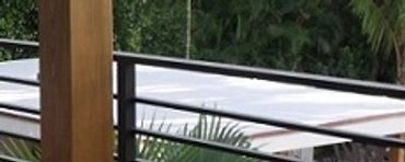 Dark horizontal-bar railings between timber columns on a covered terrace.
