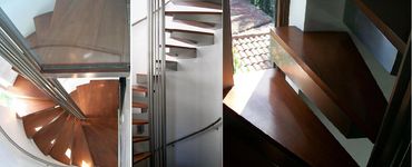 Spiral staircase details showing wood treads, metal supports and a curved wall handrail.