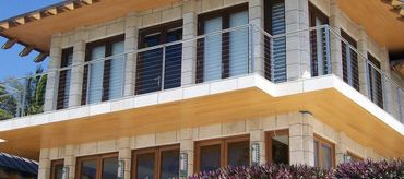 Cable balcony railing with metal posts and a slim top rail.