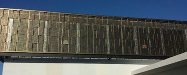 Perforated metal screen wrapping an exterior architectural opening.