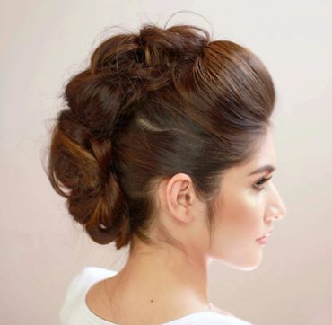 Elegant updo hairstyle on a woman with smooth, glossy brown hair.