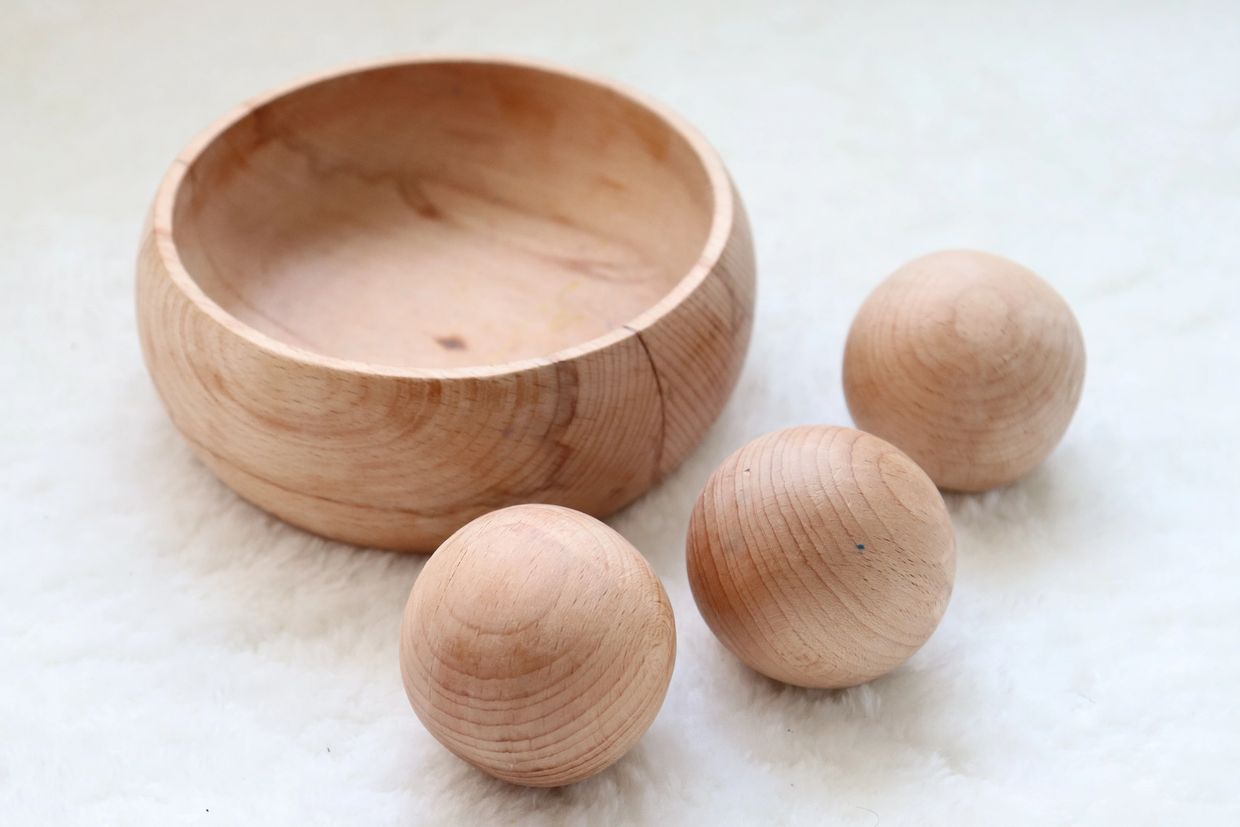 Hand-crafted wooden bowl with three wooden balls