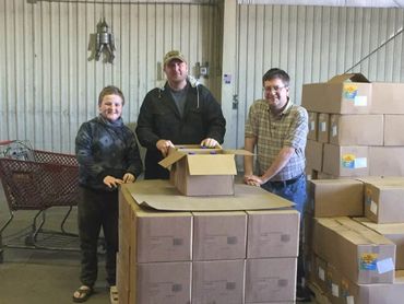 Volunteers stand behind boxes