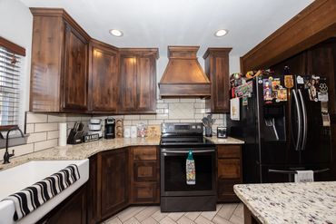 Cozy kitchen with dark wood cabinets and black appliances.