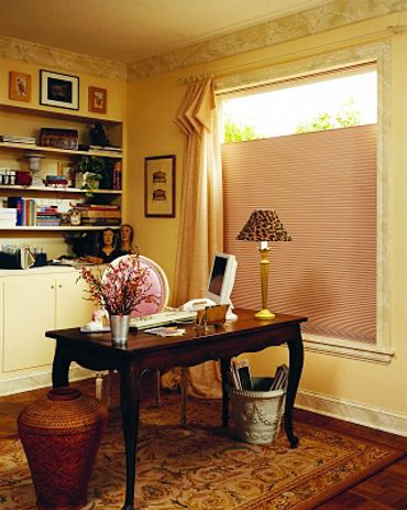 A folded yellow curtain and pink shades