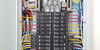 Organized electrical panel with labeled circuit breakers and color-coded wiring.