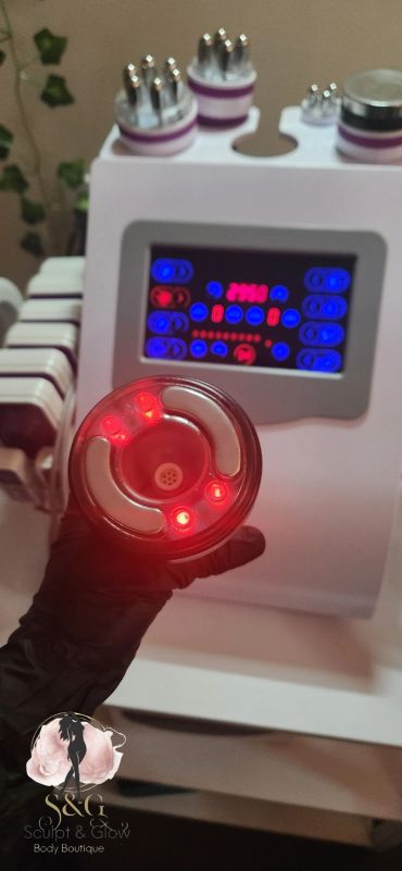 Close-up of a glowing red light device held by a gloved hand.