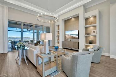 Modern living room with neutral tones and large glass doors overlooking a patio.