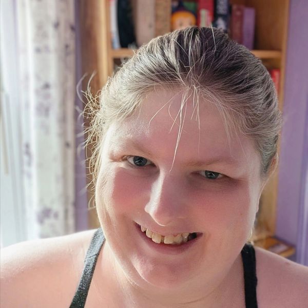 Close-up of a smiling person with gray hair.